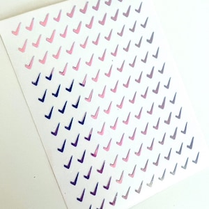 May include: A sheet of holographic stickers with a gradient of pink and blue check marks.