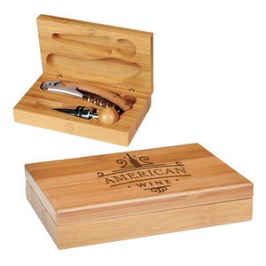 Puede incluir: Una caja de madera con un sacacorchos, un tapón de botella y dos tapones de botella. La caja está grabada con las palabras "American Wine".