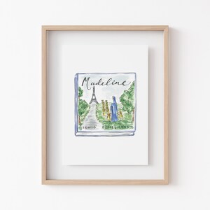 May include: A framed print of the book "Madeline" by Ludwig Bemelmans. The watercolor illustration on the cover depicts the Eiffel Tower, a path, and figures in blue and yellow. The title "Madeline" is written in cursive.