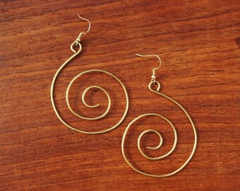 May include: A pair of gold-toned earrings with a spiral design. The earrings are made of wire and have a simple, elegant look.