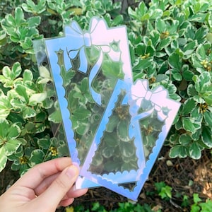 以下が含まれることがあります： 波打つ縁取りとリボンデザインの虹色の青と白のプランナー用ステッカー2枚