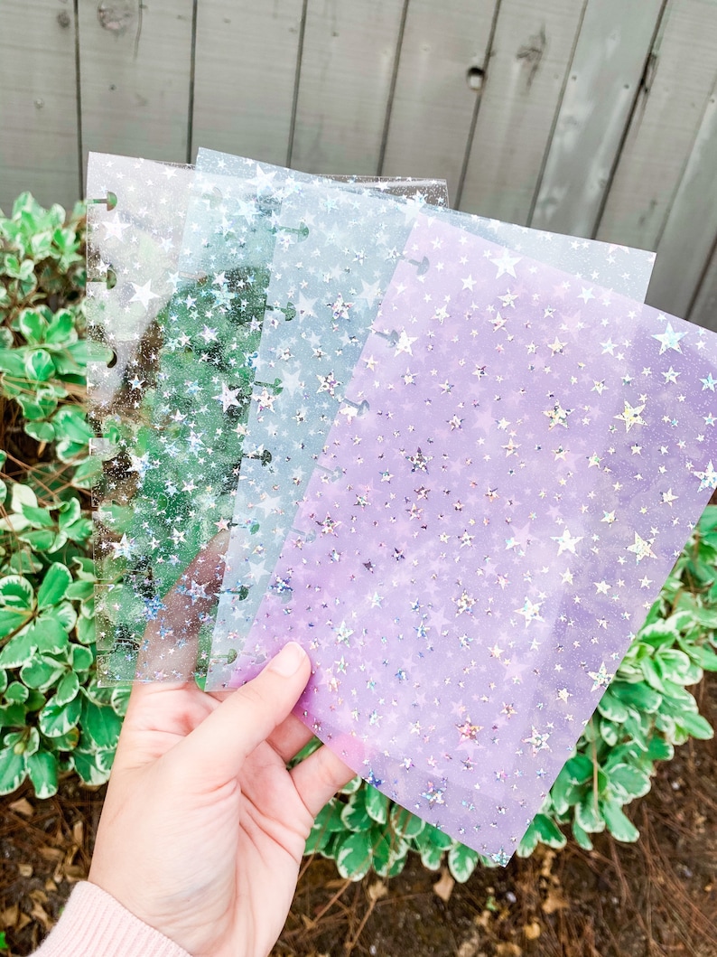 Pu&ograve; includere: Tre fogli di plastica trasparente con un motivo a stella. I fogli sono traslucidi e hanno una finitura olografica. Le stelle sono iridescenti e brillano di colori diversi.