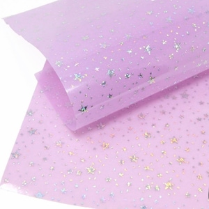 Pu&ograve; includere: Tessuto trasparente color lilla con motivo a stelle iridescenti.