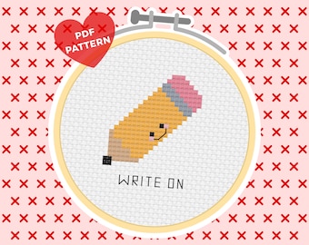 May include: A cross-stitch pattern featuring a yellow pencil with a pink eraser and the text "WRITE ON". The pattern is in a white embroidery hoop with a wooden frame.