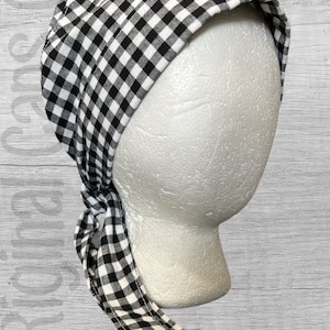 May include: Black and white gingham fabric head covering with a long tie. The fabric is a checkered pattern.