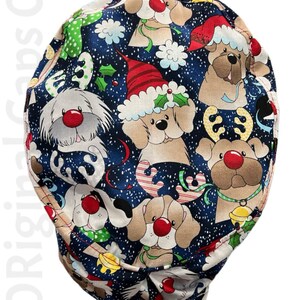May include: A blue scrub hat with a Christmas-themed print of dogs wearing Santa hats and reindeer antlers. The print is on a dark blue background with white snowflakes.