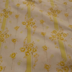 May include: White fabric with a yellow floral pattern. The pattern features yellow roses and leaves on a white background with vertical yellow stripes.