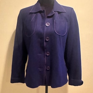 May include: A dark blue blazer with a purple trim and five buttons. The blazer has two pockets with a curved top edge.