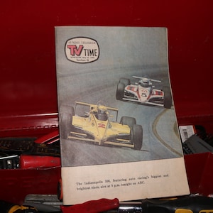 Puede incluir: Una portada de revista TV Guide vintage con una foto de dos coches de carreras en una pista. La revista se titula "TV Time" y el texto dice "The Indianapolis 500, featuring auto racing's biggest and brightest stars, airs at 3 p.m. tonight on ABC."