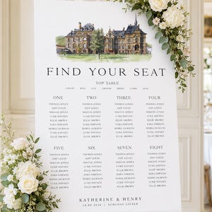 May include: A white wedding seating chart on an easel, adorned with floral arrangements. The chart features a watercolor illustration of a building and the text "FIND YOUR SEAT". Names are listed under table numbers.