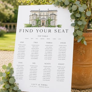 May include: A white wedding seating chart with the text "FIND YOUR SEAT" and a watercolor illustration of a stately home. The chart lists guest names under table numbers. The sign is propped up near a potted plant.