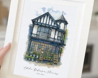 May include: A framed watercolor illustration of a two-story shop with dark blue timber framing and large windows. The storefront displays various potted plants on wooden stands. The text reads Chloe Robinson and Chloe Robinson Flowers EST.2023.