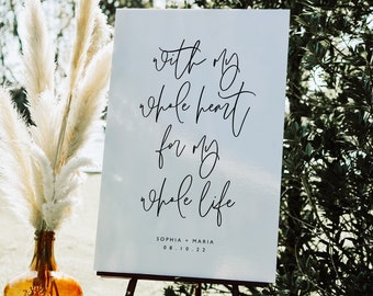 May include: White sign with black calligraphy that reads "with my whole heart for my whole life" and the names "Sophia + Maria" and the date "08.10.22".