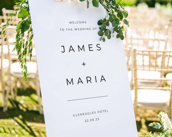 May include: White wedding sign with greenery on a white easel. The sign reads "Welcome to the wedding of James + Maria Gleneagles Hotel 22.06.23".