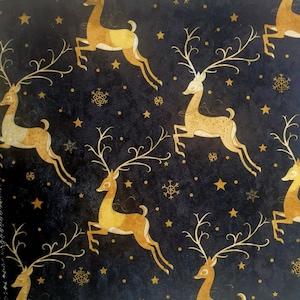 May include: Black fabric with a gold repeating pattern of stylised reindeer with antlers. The background is black with gold stars and snowflakes.