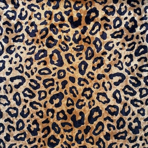 May include: A brown fabric with a black leopard print pattern. The fabric has a soft, velvety texture.