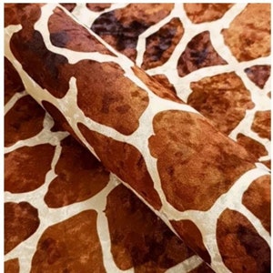 May include: Close-up of a brown and white fabric with a giraffe print. The fabric has a velvety texture.