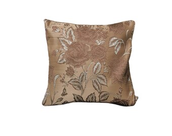 May include: A beige throw pillow with a floral pattern featuring brown and white roses and leaves.
