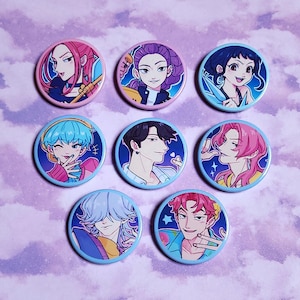 Può includere: Una collezione di sette spille rotonde e colorate con illustrazioni di personaggi in stile anime. Ogni spilla ha un bordo blu e mostra un personaggio diverso con acconciature ed espressioni uniche. Lo sfondo è un viola chiaro con un motivo sottile.