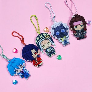 May include: Five colorful character charms with keychains. The characters are a blue-haired boy, a red-haired girl, a green-haired boy, a white-haired boy with a gas mask, and a brown-haired girl with a red headband.
