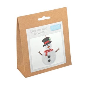 May include: A brown cardboard box with a white label that says "Make Your Own Snowman" and features a picture of a snowman with a black top hat, red scarf, and white buttons. The box is for a craft kit.