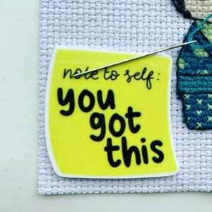 May include: A yellow sticky note with the text "note to self: you got this" written in black. A needle is threaded through the note.
