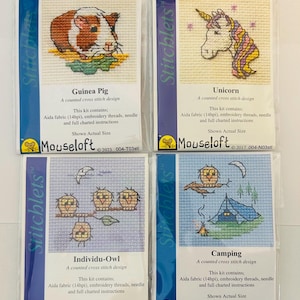 May include: Four cross-stitch kits with animal and nature themes. Designs include a guinea pig, a unicorn, owls, and a camping scene. Each kit contains Aida fabric, embroidery threads, a needle, and instructions. The brand name is Mouseloft.