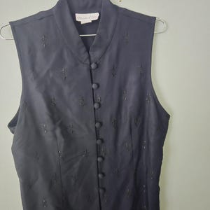 Blusa negra sin mangas bordada con flor de lis de la marca Vintage Pride & Joy, talla M-L