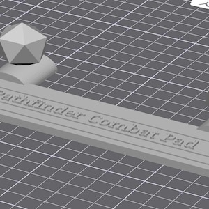 May include: A gray 3D-printed Pathfinder Combat Pad. The pad features a rectangular base with the text "Pathfinder Combat Pad" and includes geometric shapes and a 20-sided die.