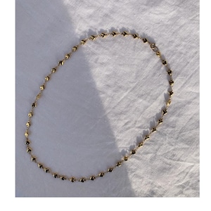 Könnte beinhalten: Eine goldene Halskette mit Herzform. Die Kette besteht aus kleinen, miteinander verbundenen Herzen.