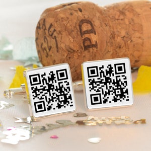 May include: A pair of silver cufflinks with a black and white QR code design.