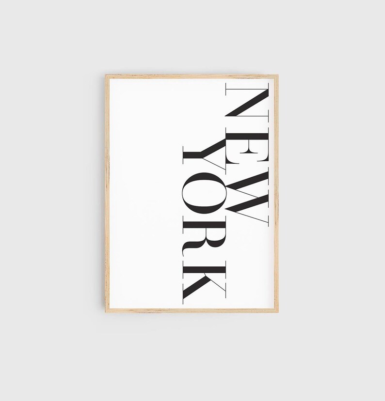 K&ouml;nnte beinhalten: Ein gerahmter Druck mit dem Wort "NEW YORK", das vertikal in einer fetten, serifenlosen Schrift geschrieben ist.