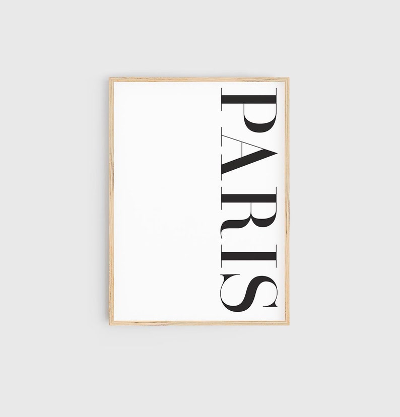 K&ouml;nnte beinhalten: Ein gerahmter Druck mit dem Wort "PARIS" vertikal in schwarzem Text auf wei&szlig;em Hintergrund.