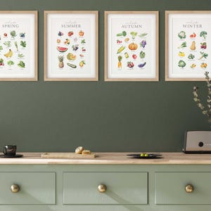 May include: Four framed prints on a green wall, each featuring a different season of the year with a list of fruits and vegetables. The prints are labeled "Spring", "Summer", "Autumn", and "Winter".