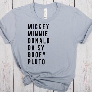 May include: A light blue t-shirt with black text that reads "Mickey Minnie Donald Daisy Goofy Pluto".