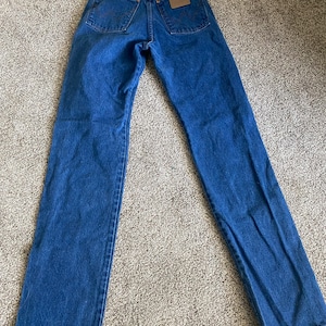 May include: A pair of blue denim jeans with a brown leather patch on the back pocket.