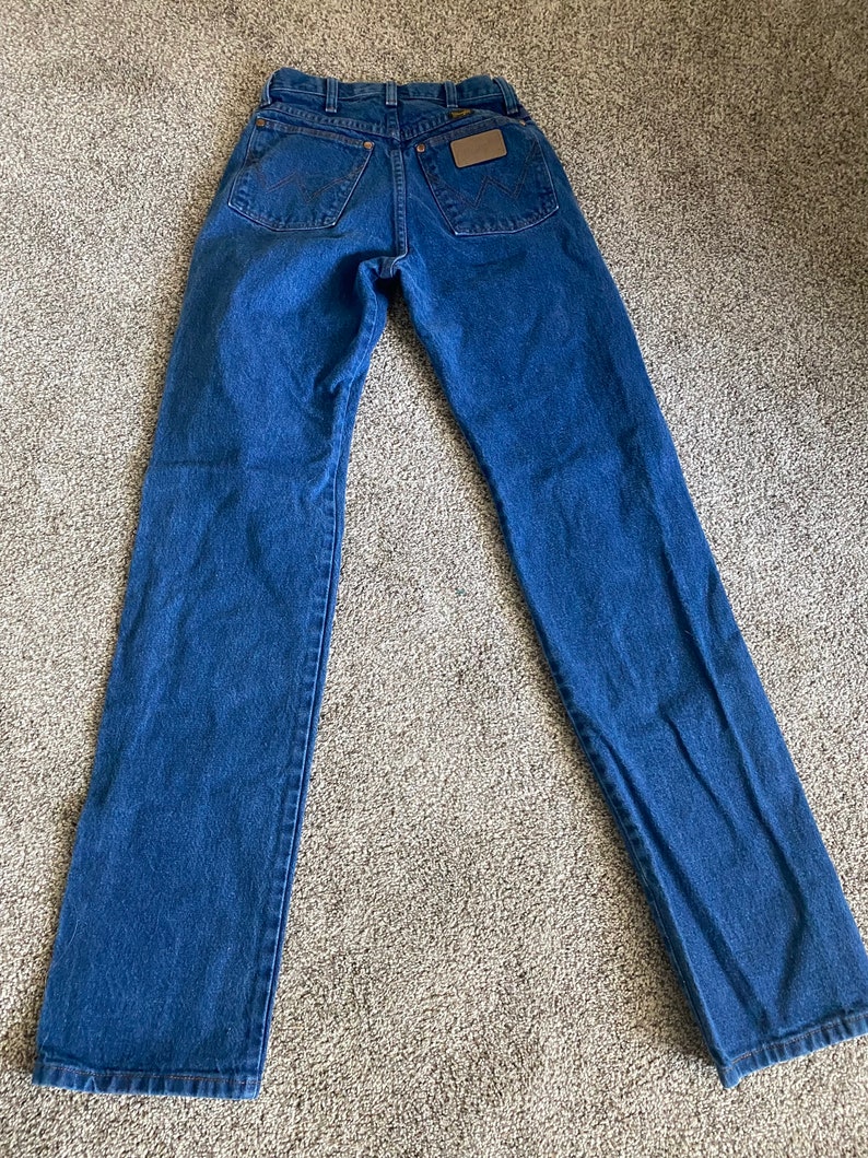 May include: A pair of blue denim jeans with a brown leather patch on the back pocket.