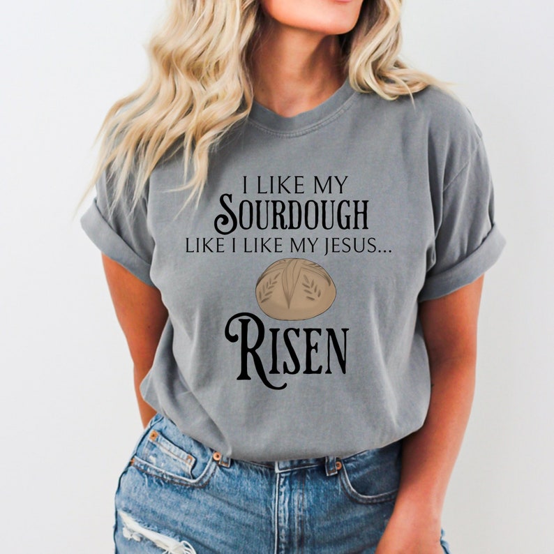 May include: Gray t-shirt with a graphic of a sourdough bread loaf and the text "I like my sourdough like I like my Jesus... Risen".