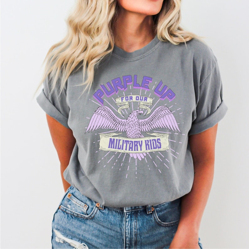 May include: A heather grey t-shirt with a purple eagle graphic and the text "Purple Up for Our Military Kids".
