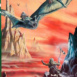 May include: A magazine cover for White Wolf Magazine, issue #27, June/July. The cover features a green bat flying over a mountainous landscape with a red sky. The text "Annual PBM Issue" is in the top left corner. The text "StarKhan Legends, Middle-Earth PBM, Torg, Ars Magica, Live-Action RPG" is in the bottom left corner.