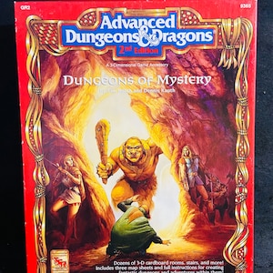 Puede incluir: Una caja roja con un borde dorado y una imagen de una escena de fantasía. La caja es para un accesorio de juego de Dungeons & Dragons llamado "Dungeons of Mystery" por Tim Beach y Dennis Kauth. La caja está etiquetada como "Advanced Dungeons & Dragons 2nd Edition".