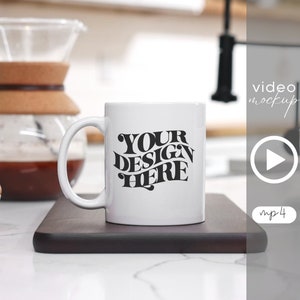 Op de afbeelding: Een witte keramische mok met een zwart ontwerp met de tekst "YOUR DESIGN HERE" op een houten snijplank.