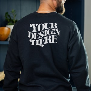 以下が含まれることがあります： 白い文字で「YOUR DESIGN HERE」と印刷された、黒い長袖のトレーナー