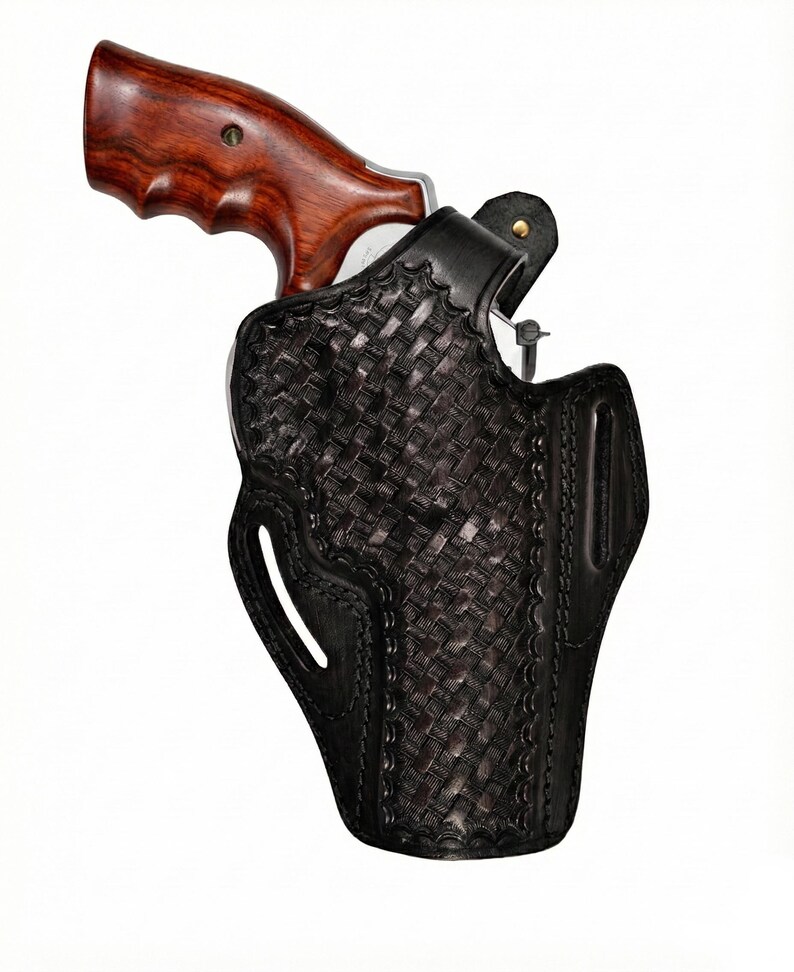 May include: A black leather holster with a woven pattern, holding a revolver. The revolver has a wooden grip. The holster features a belt loop and a decorative stitched edge.
