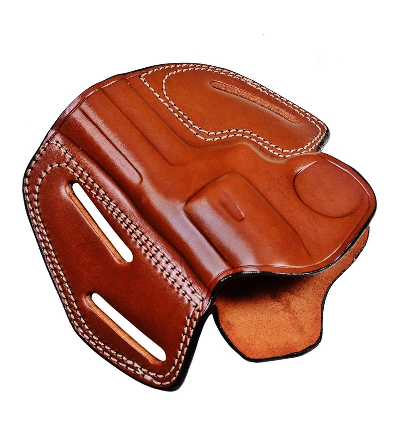 May include: A brown leather holster with white stitching. The holster has a cut-out for a gun and a belt loop.