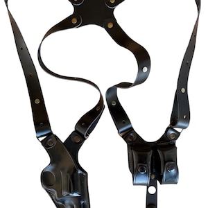 Peut inclure: Holster d'&eacute;paule en cuir noir avec un &eacute;tui &agrave; pistolet et deux pochettes &agrave; magazines. Le holster est dot&eacute; de sangles r&eacute;glables et de rivets de couleur laiton. Le design est sym&eacute;trique.