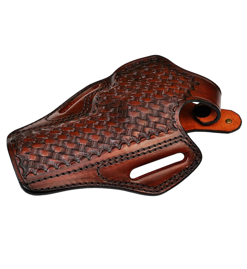 May include: A brown leather holster with a basketweave pattern. The holster has a curved shape with a belt loop and a snap closure. The edges are stitched with dark thread.