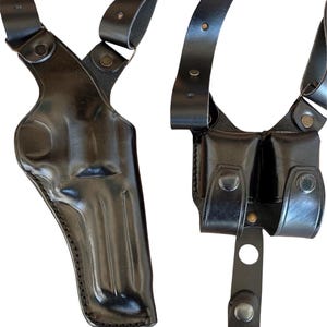 Pu&ograve; includere: Un porta-pistola a spalla in pelle nera con due tasche per caricatori. Il porta-pistola ha cinturini regolabili e una chiusura a scatto.