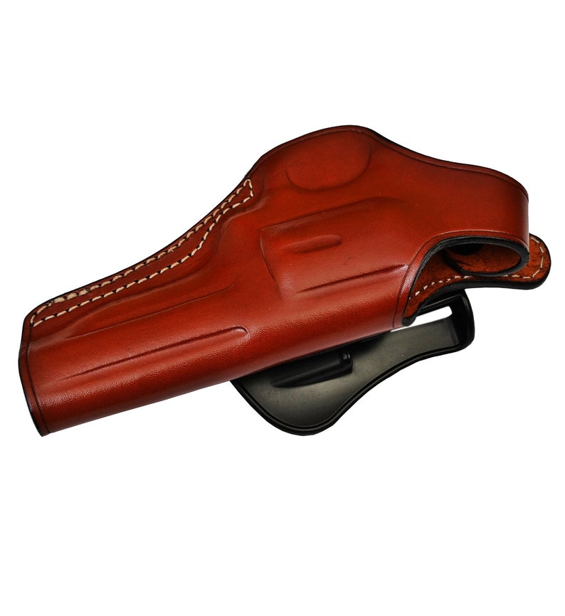May include: A brown leather holster for a handgun. The holster has a belt loop and a snap closure.
