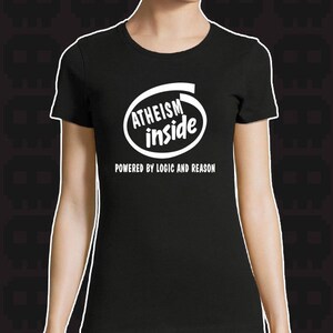 Puede incluir: Camiseta negra con un gráfico blanco de un icono de computadora que dice "Atheism inside" y el texto "Powered by logic and reason".